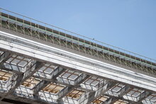 Underside of a run-down bridge against a blue sky