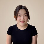 Hyeree Ellis is wearing black and smiles at the camera in front of a beige background.