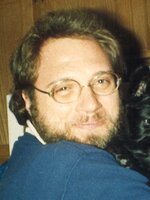 Professor William Schroeder looks at the camera and smiles while holding his dog.